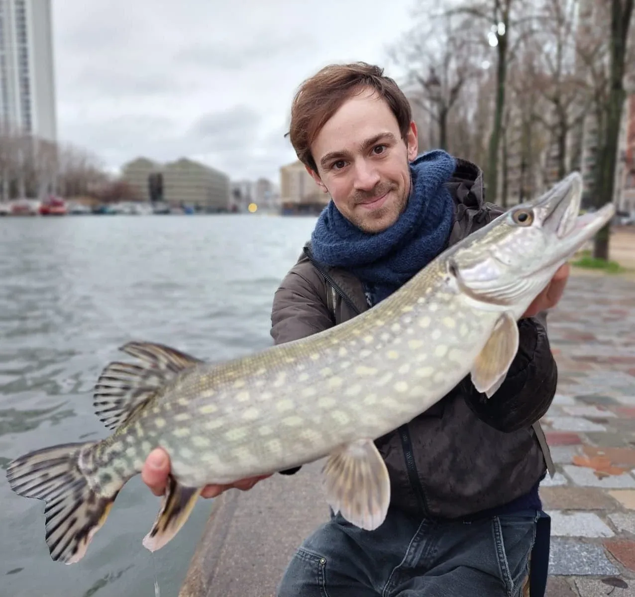 A Frenchman holds a spotted pike he caught in the now-cleaner Seine river